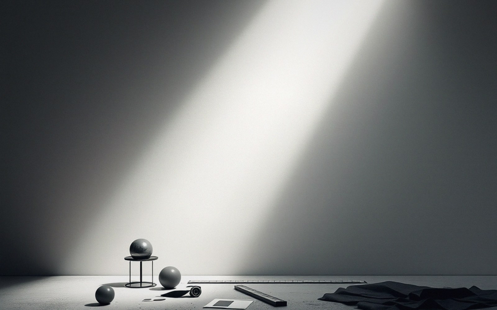 Spheres, a coiled tape and a ruler on a table lit by a diagonal light beam